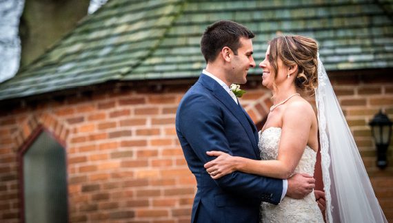 A newly wed couple outside the Chapel Garden at Abbeywood Estate wedding venue in Cheshire